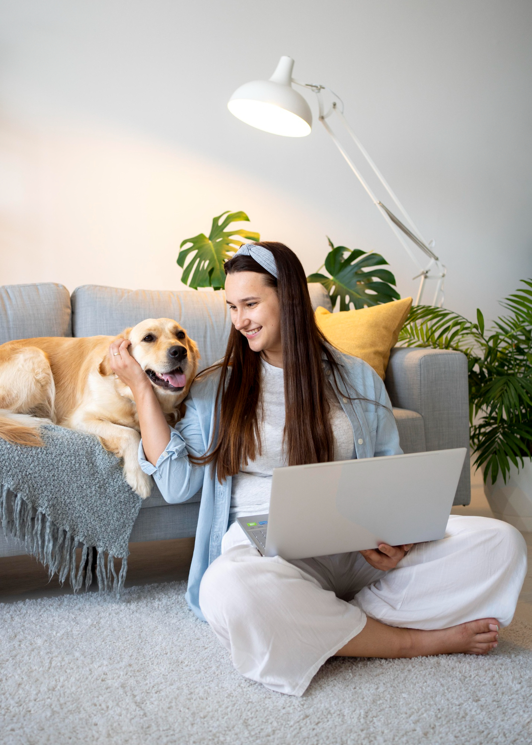A person sits on a couch with a laptop